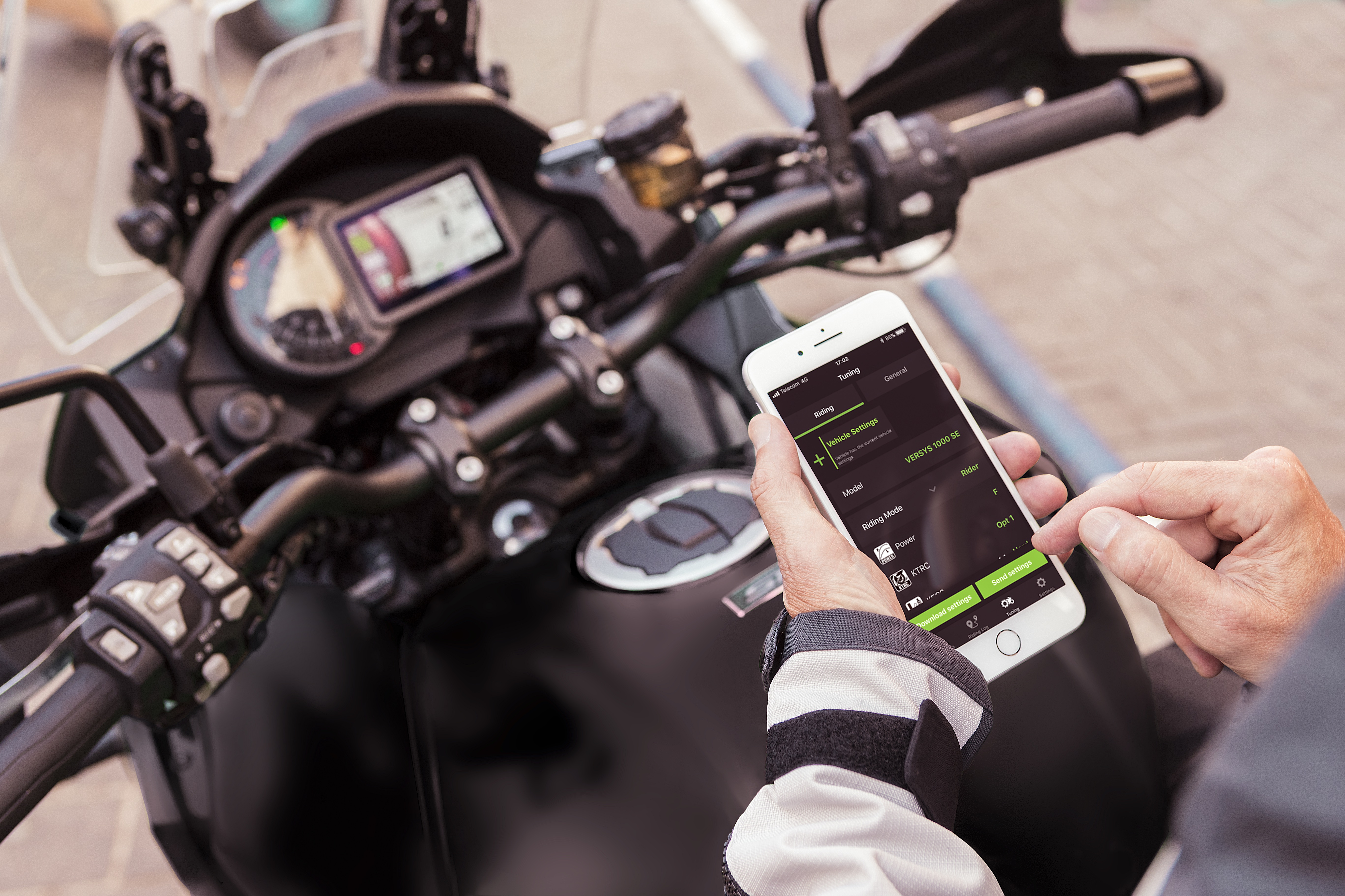 Rider using RIDEOLOGY THE APP on phone on their Kawasaki motorcycle